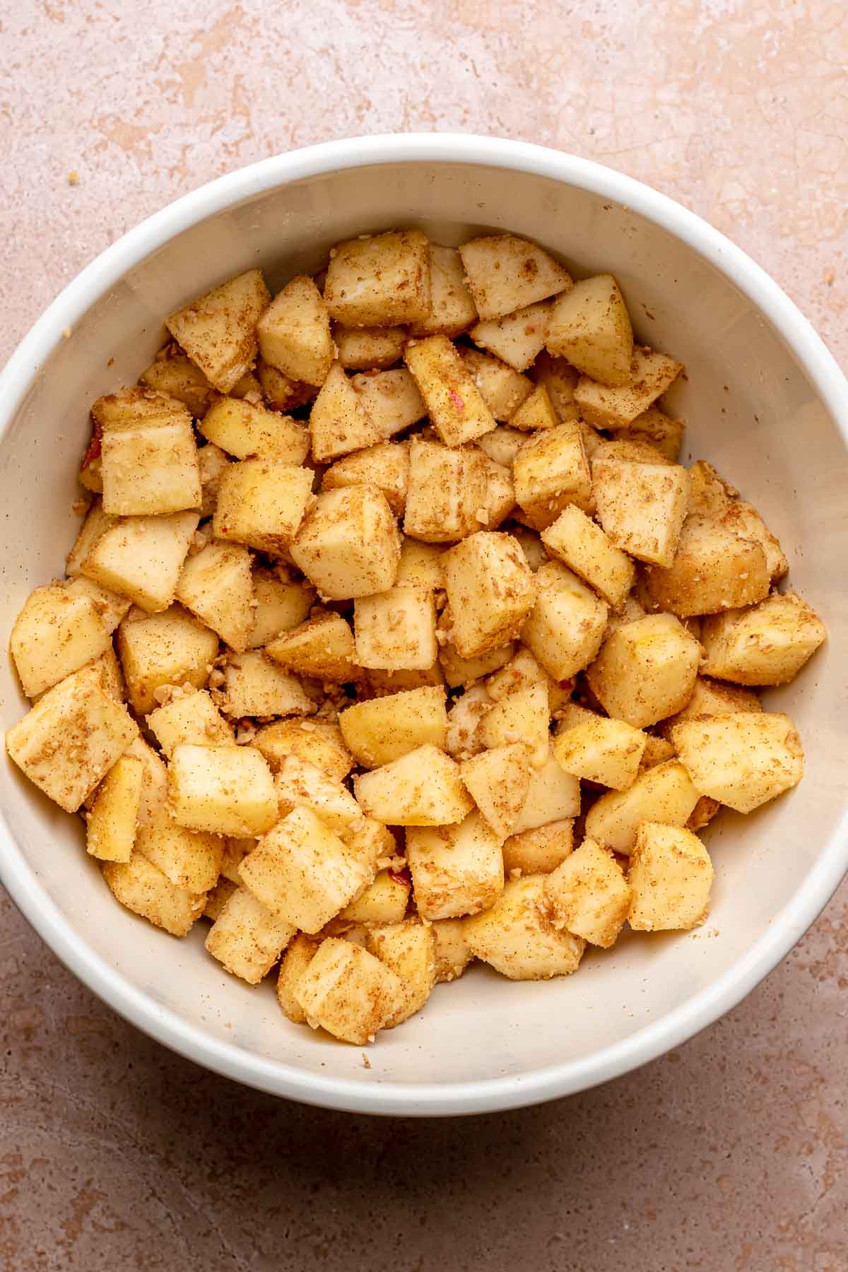 Chopped cinnamon apples in a mixing bowl.