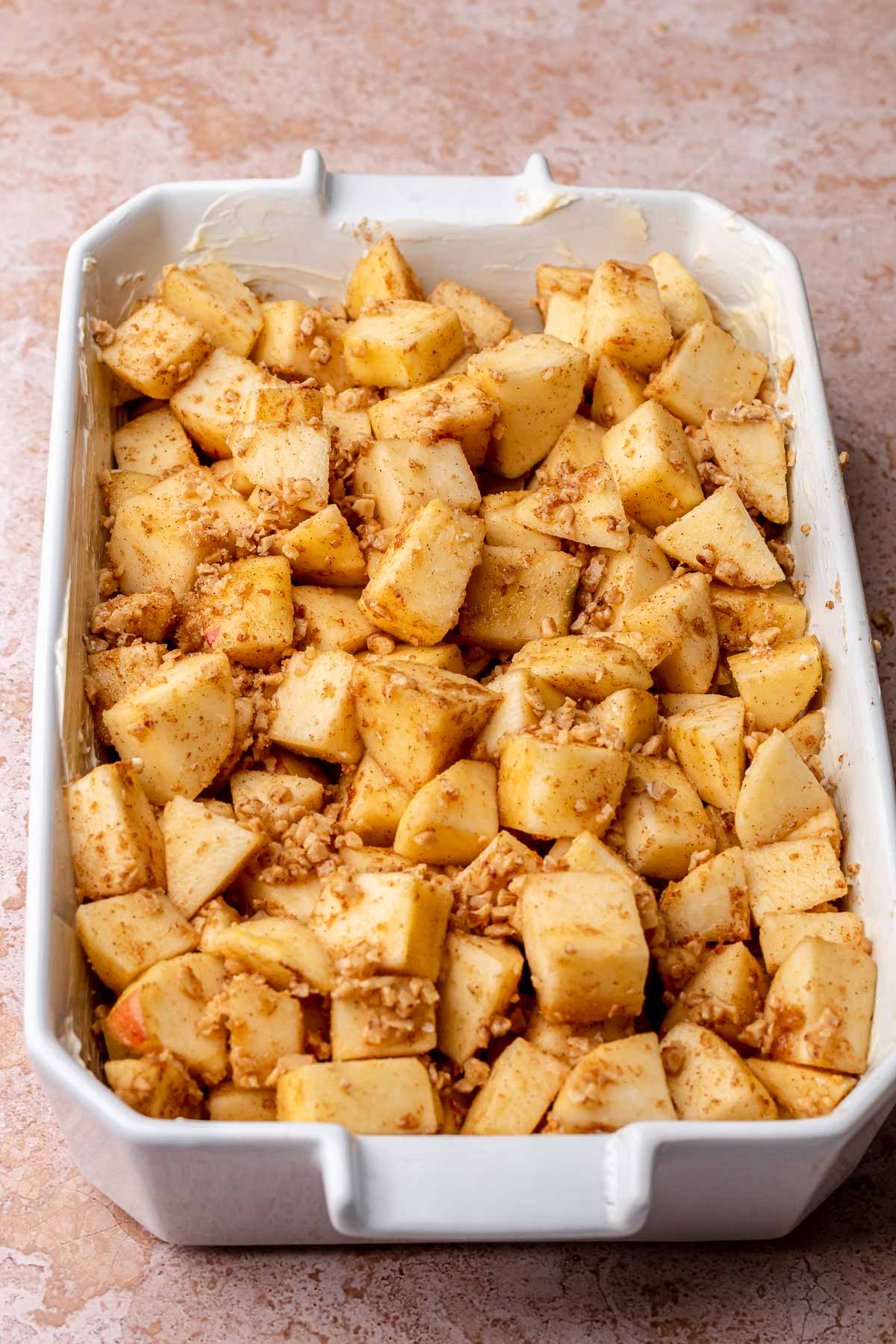 Cinnamon apples in a buttered casserole dish.