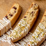 Three pieces of biscotti with white chocolate drizzled on top.