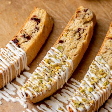 Three pieces of biscotti with white chocolate drizzled on top.