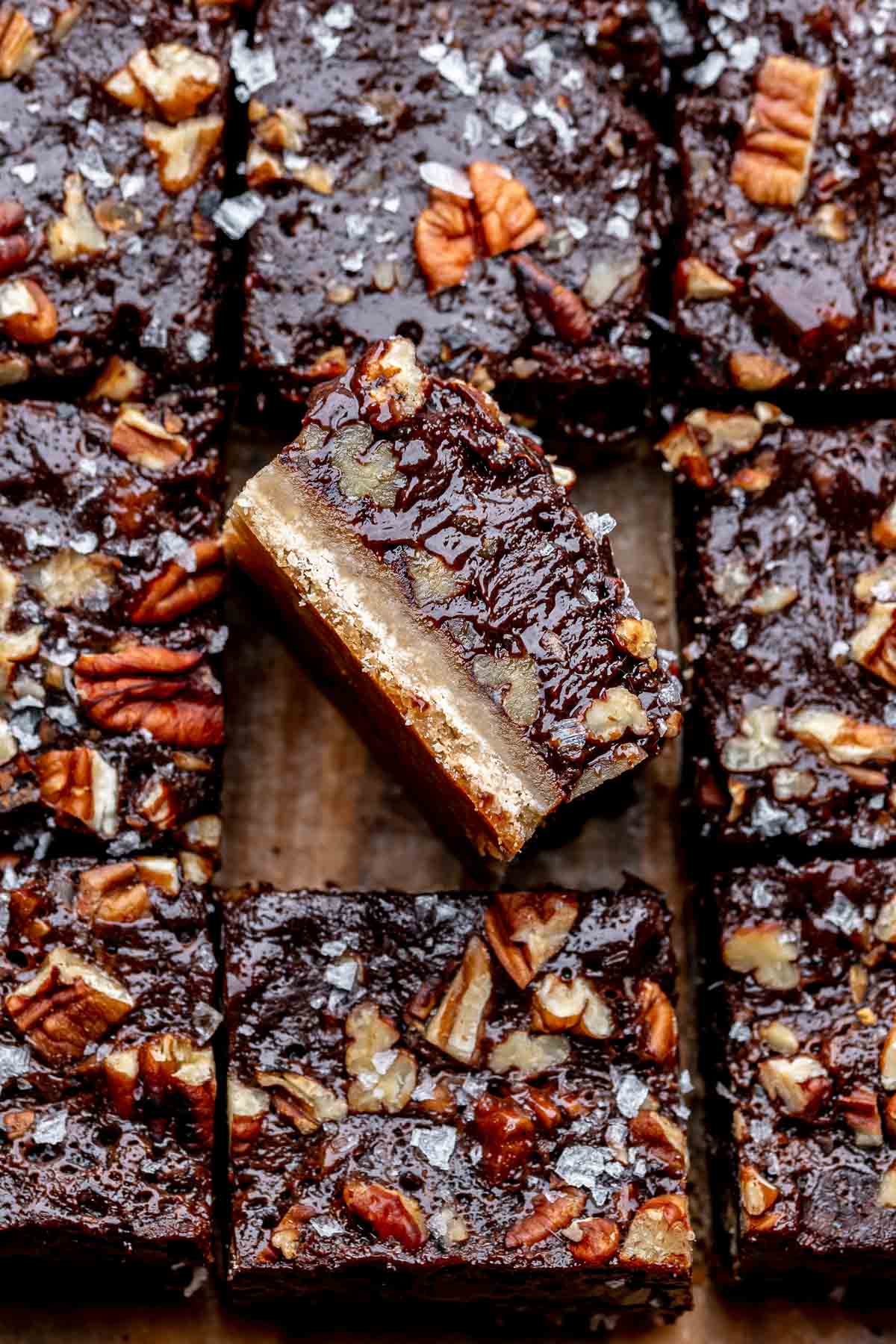 A piece of chocolate pecan pie bar laying on its side.