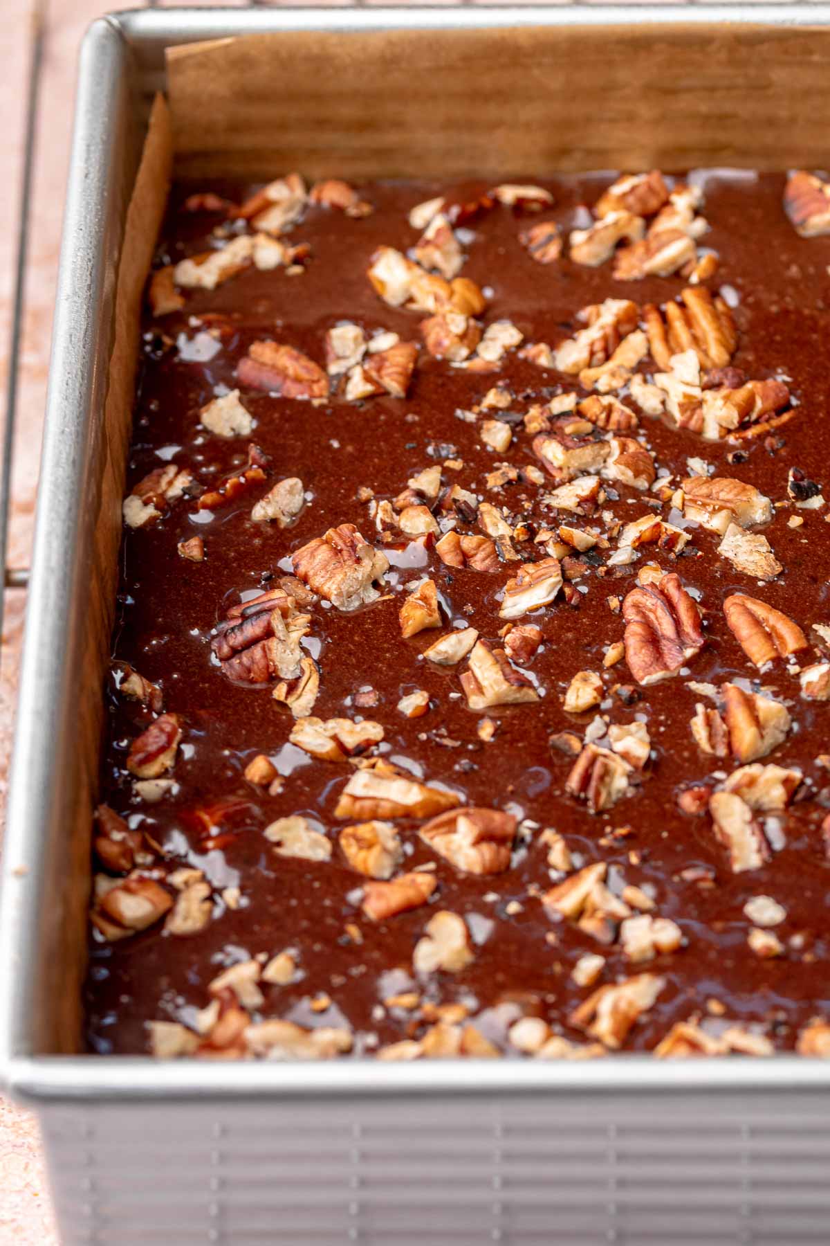 Pre-baked chocolate pecan pie bars with extra pecans scattered on top.