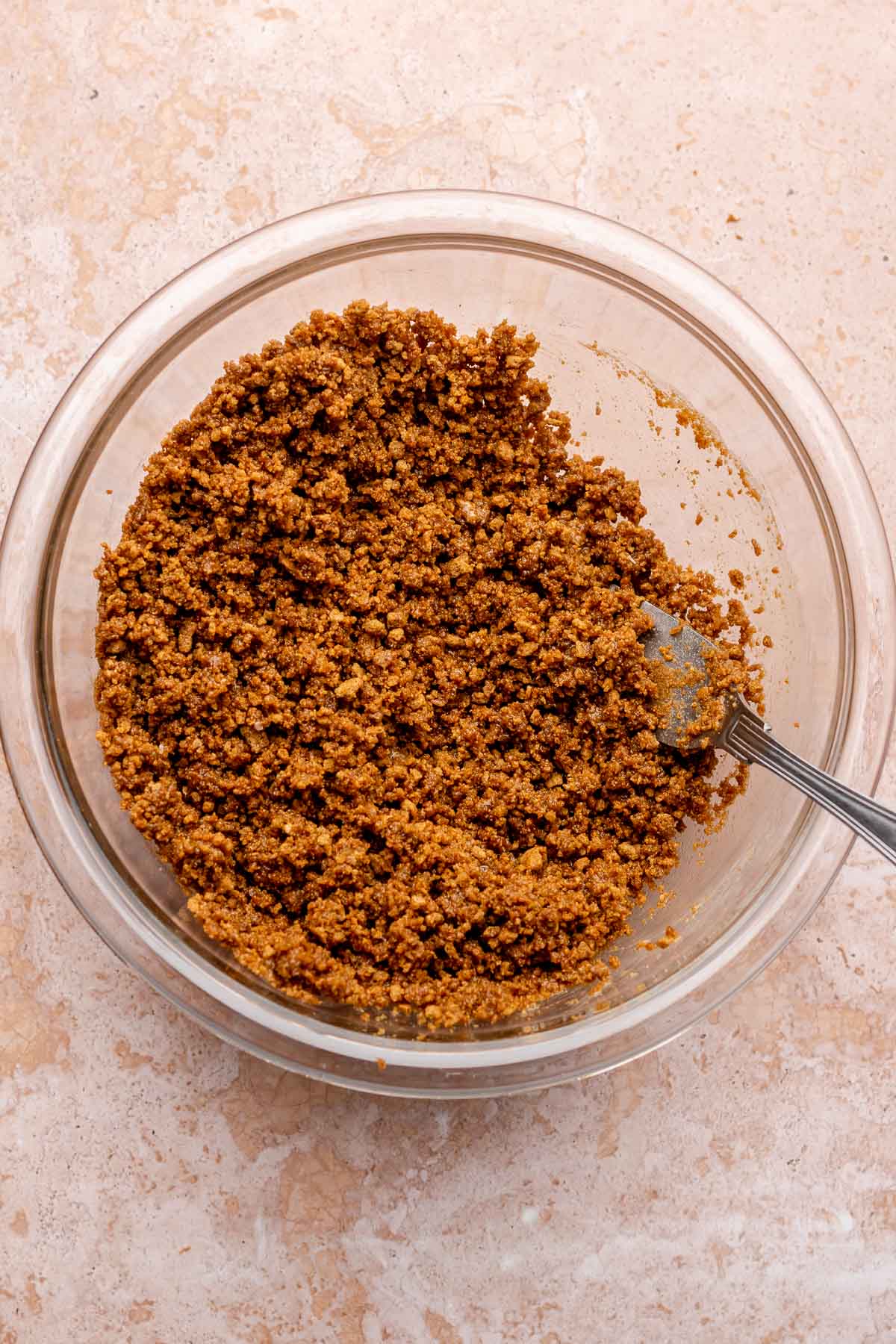 Gingersnap crust crumbles in a bowl with a fork.