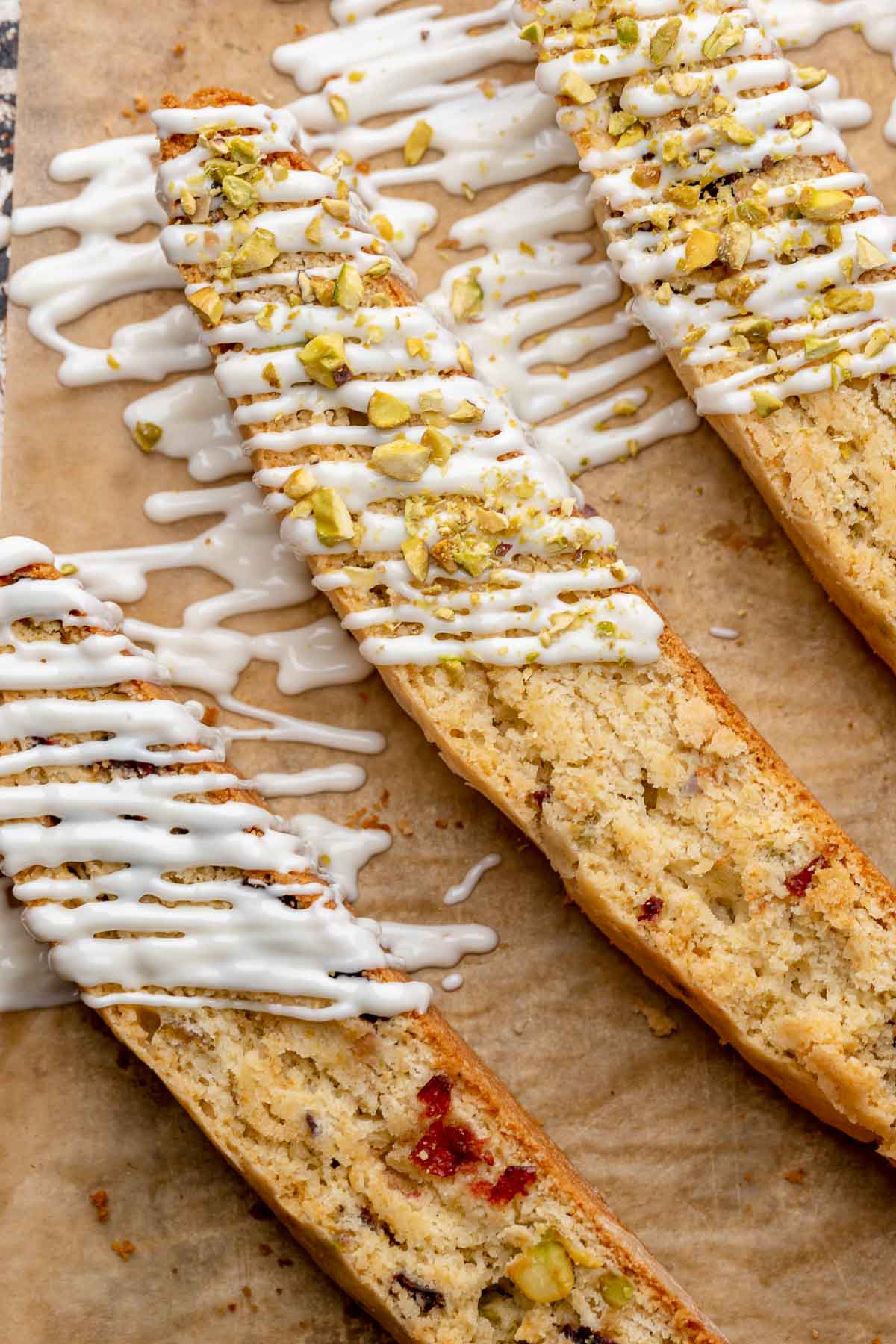 Three pieces of biscotti with white chocolate drizzled on top.