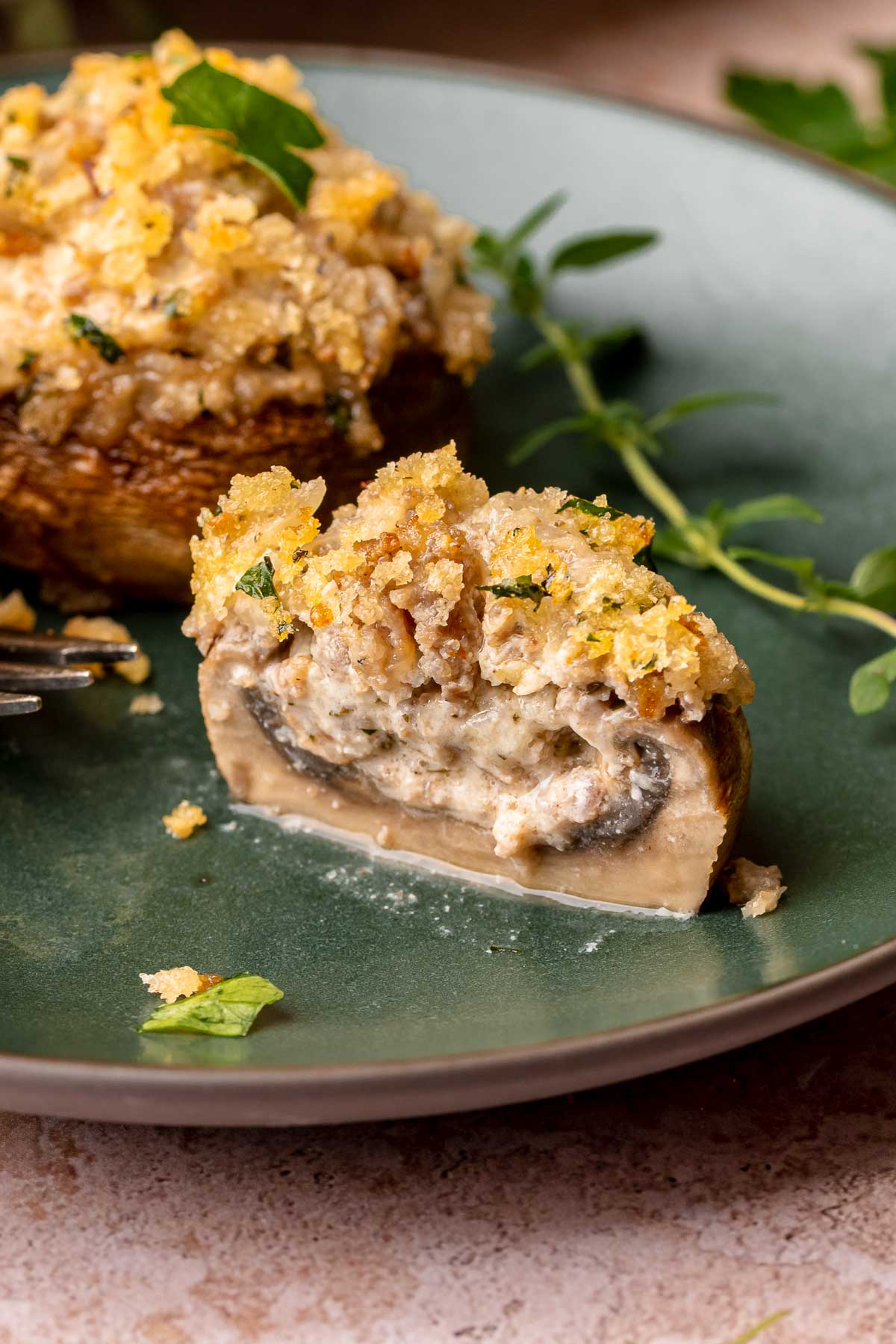 A boursin stuffed mushroom cut open on a plate.