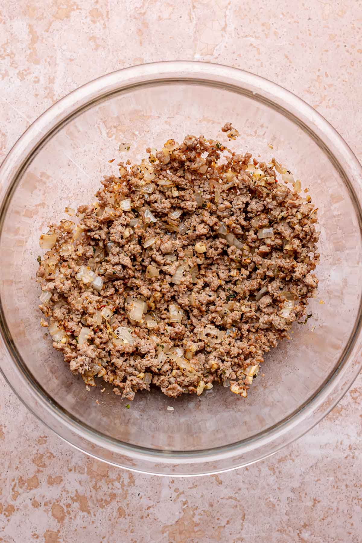Cooked ground sausage and onions in a large mixing bowl.