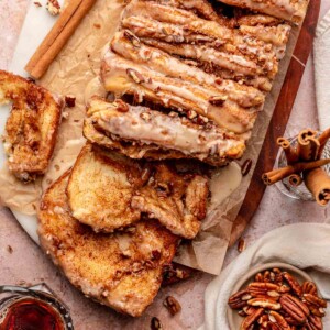 Cinnamon pull apart bread on a cutting board with two slices pulled down.