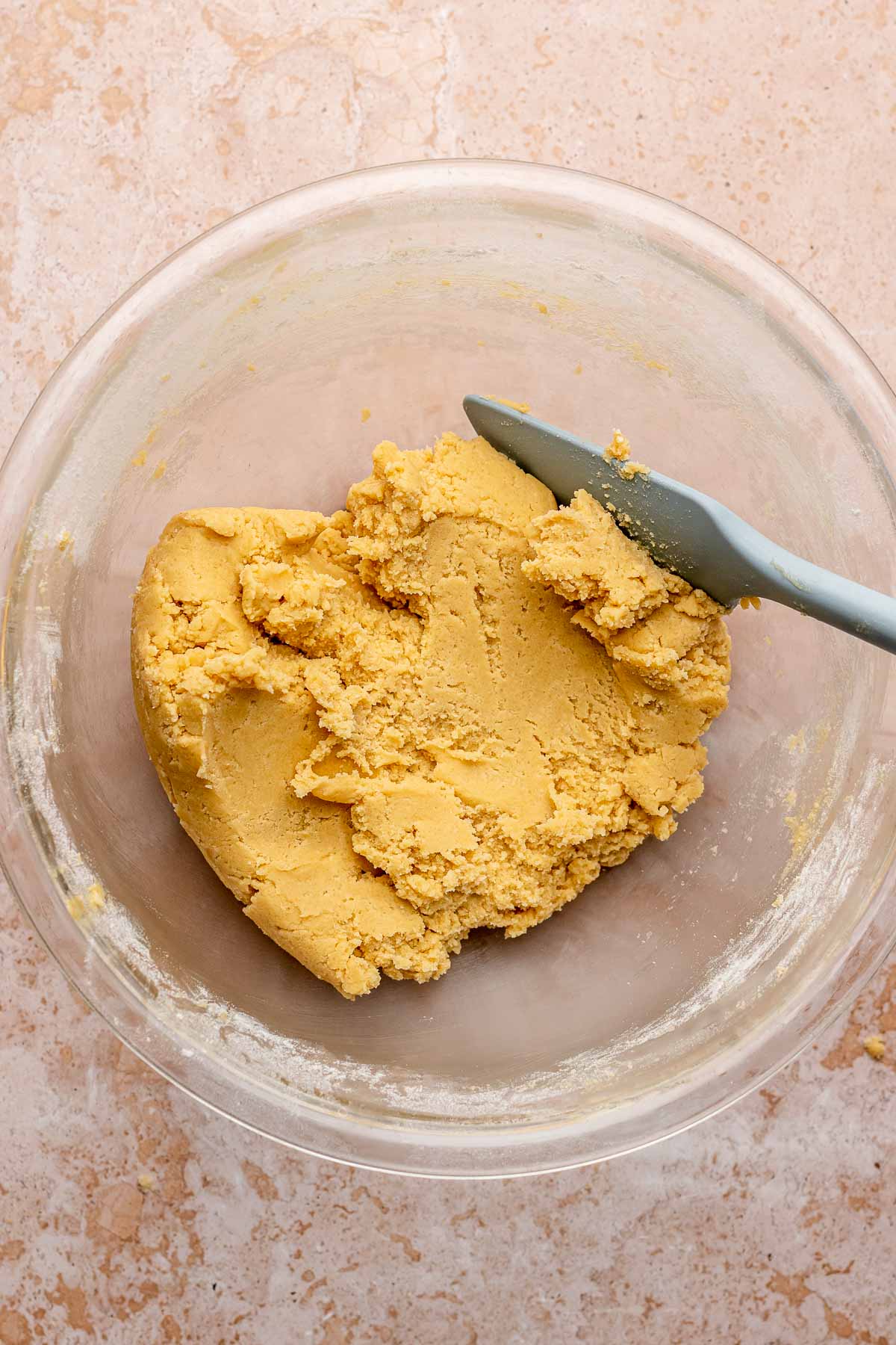 Finished cookie dough in a bowl with a rubber spatula.