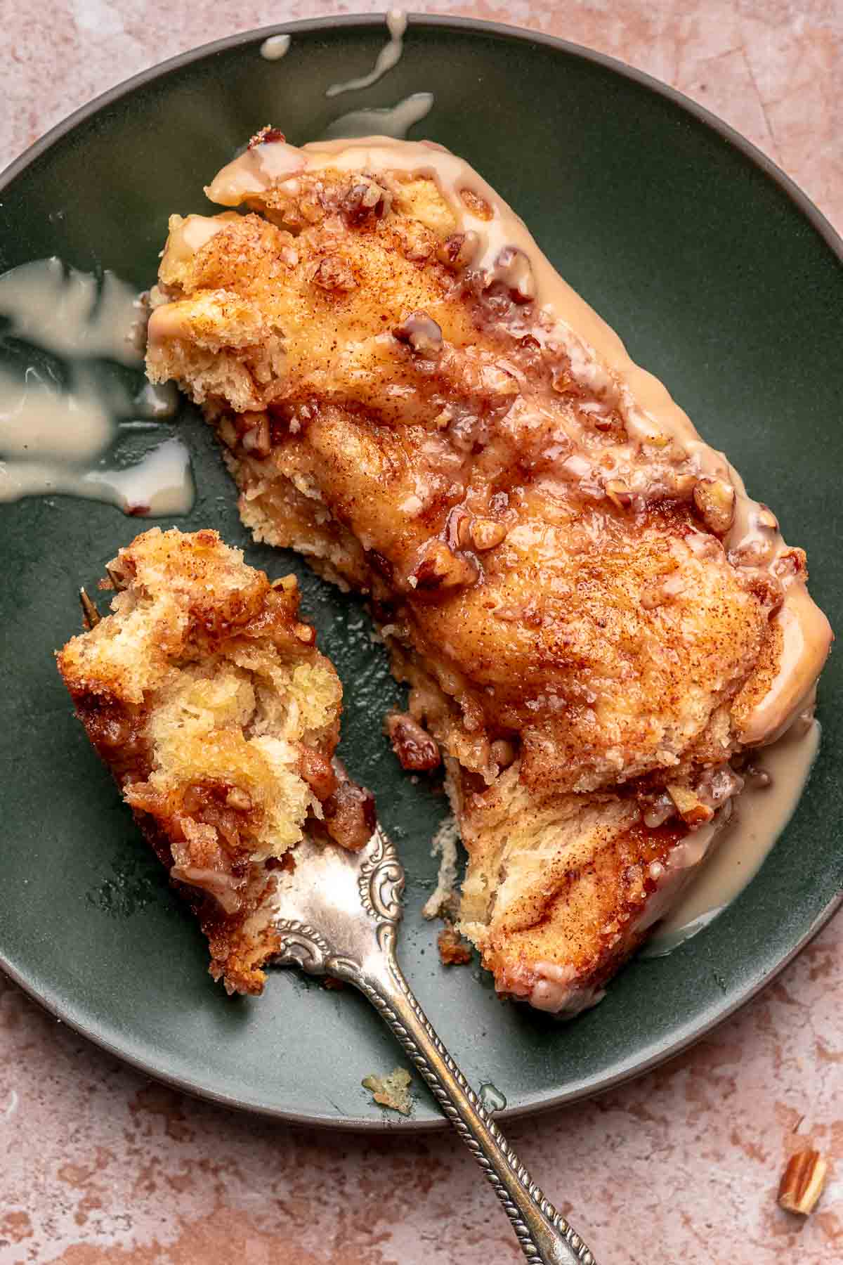 A piece of cinnamon pull apart bread on a plate with a fork.