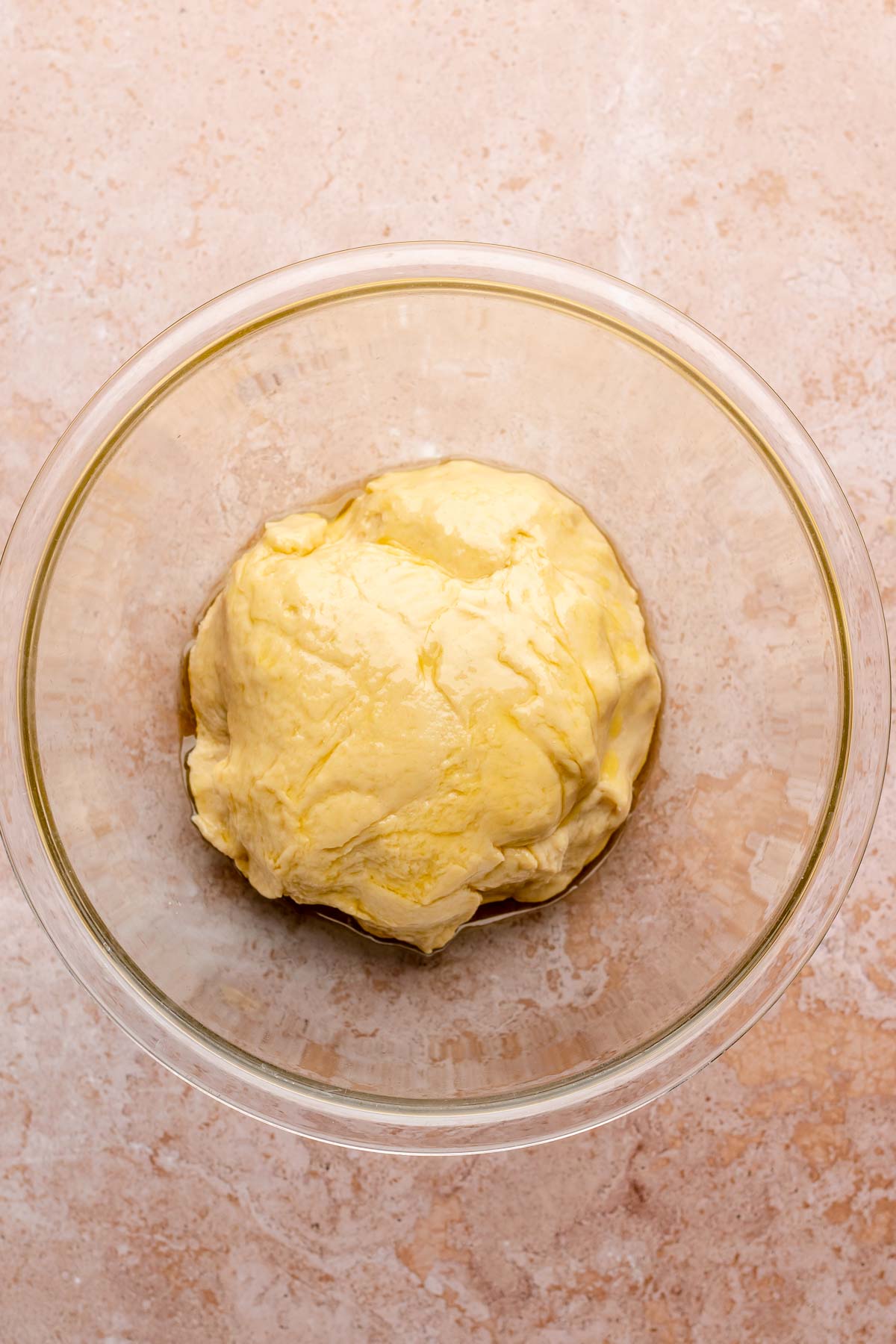 Oiled dough in a mixing bowl ready to rise.