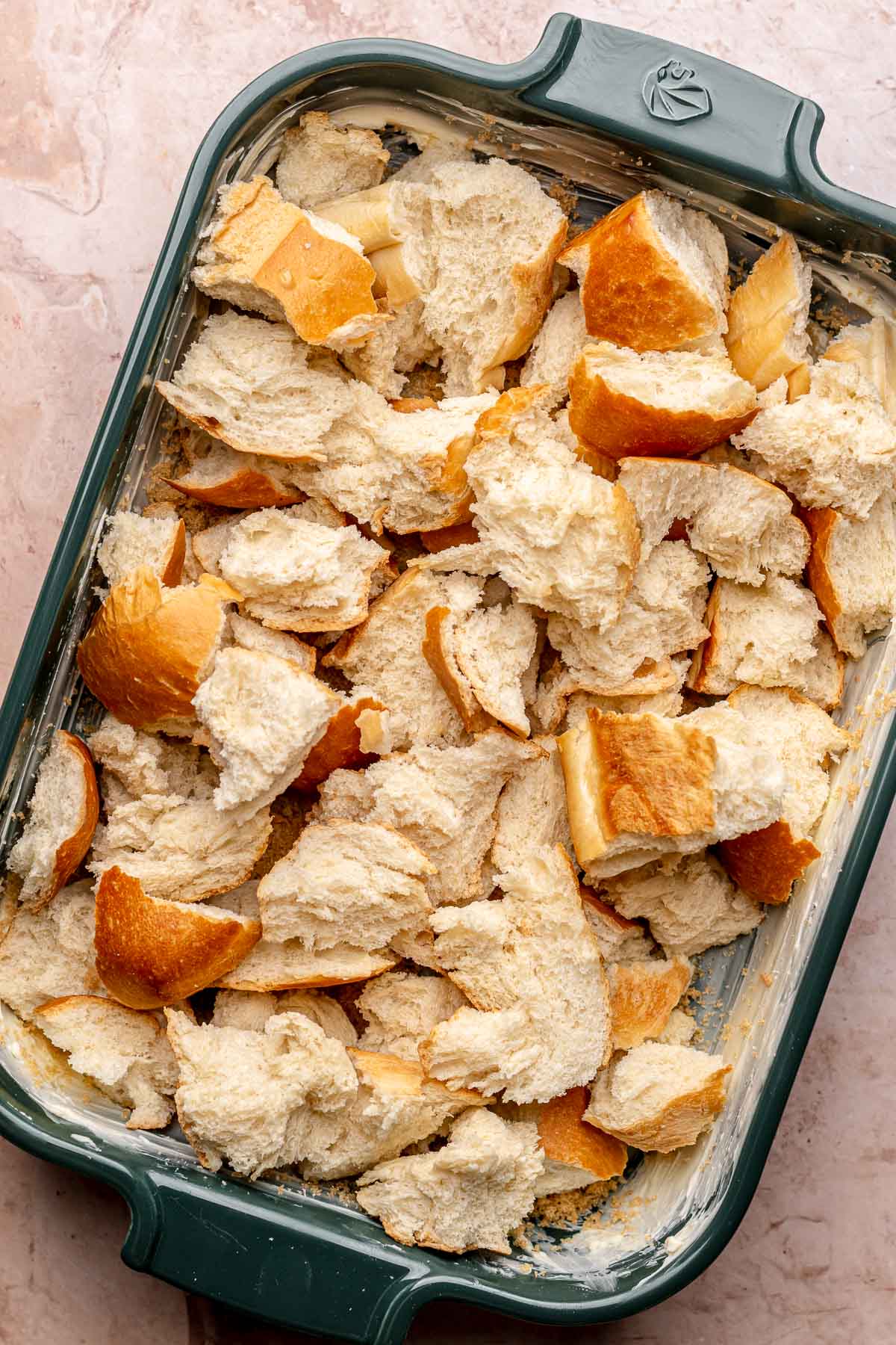 Torn pieces of bread layered in a casserole dish.