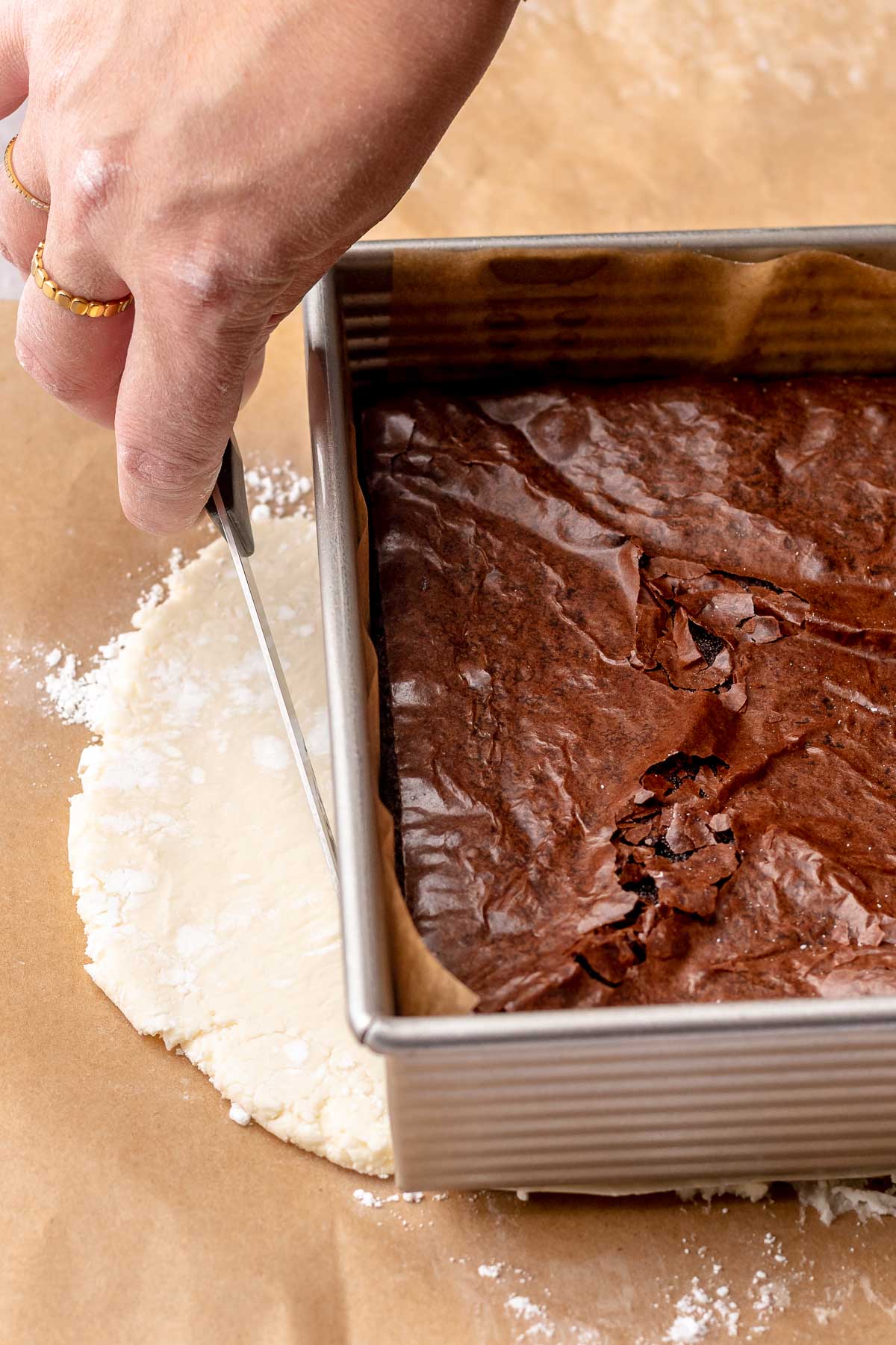 A hand cuts peppermint filling into a square.