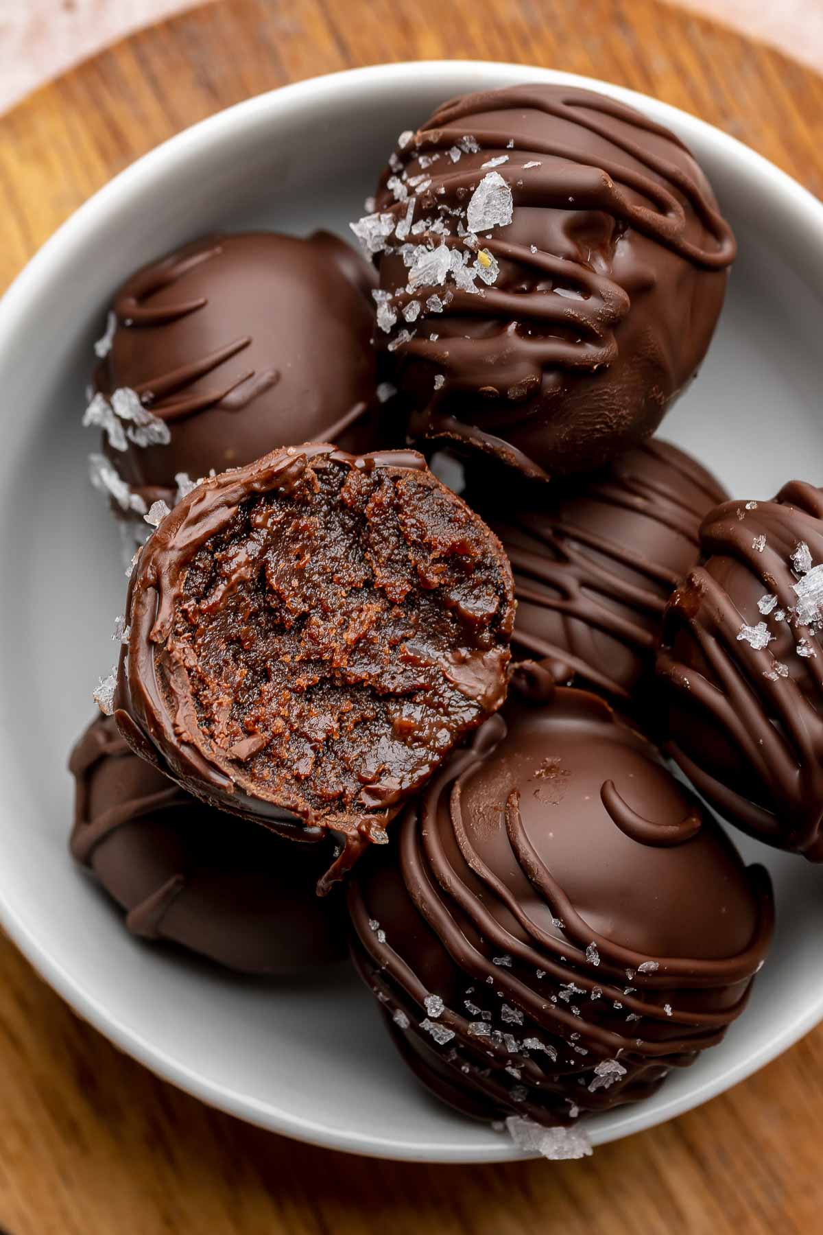 Brownie truffles in a bowl. The top one has a bite removed.