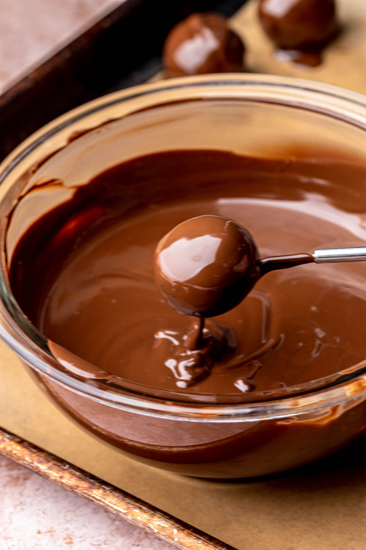 A dipped, rolled brownie truffle in melted chocolate.
