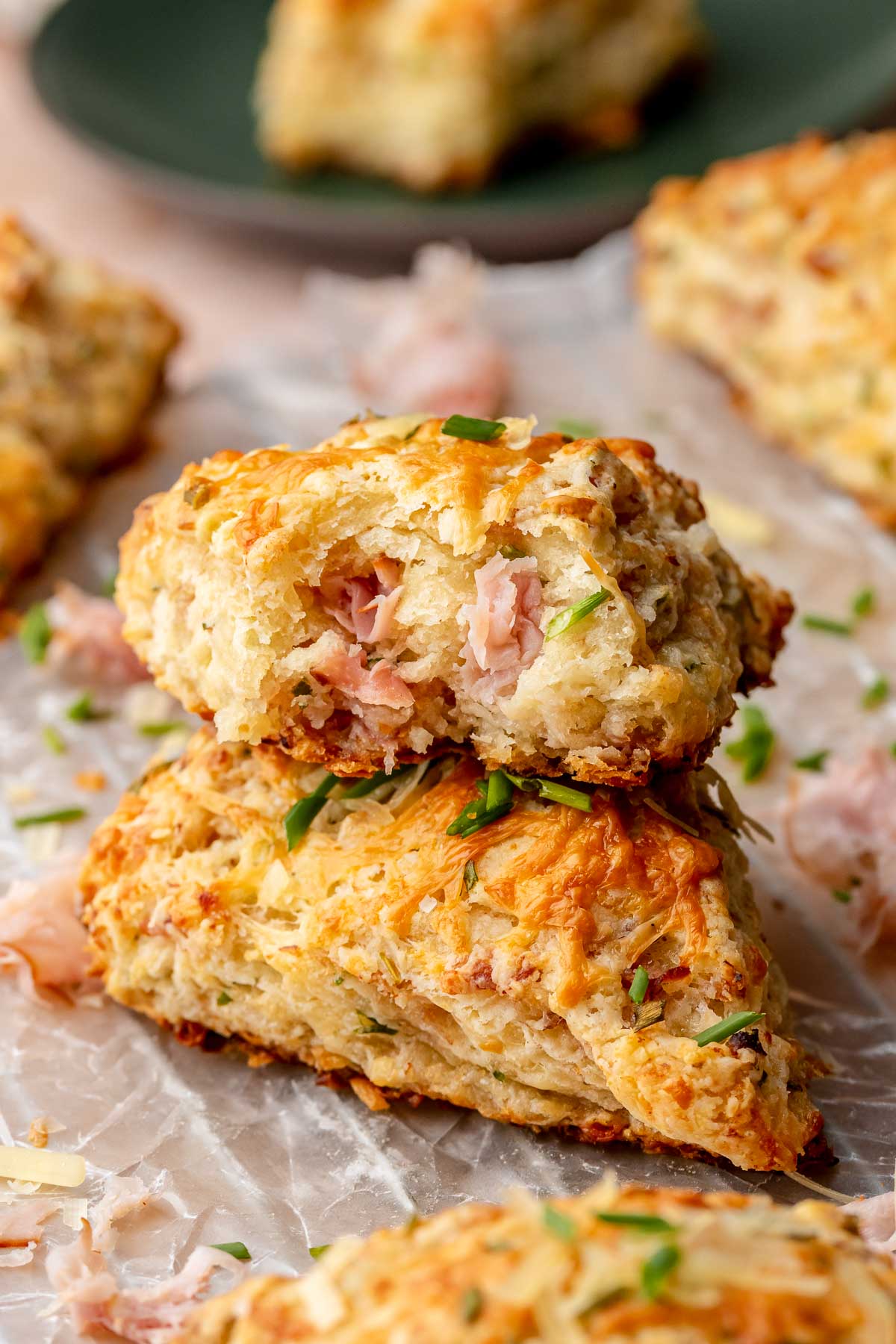A stack of ham and cheese scones. The top scone has a bite removed.