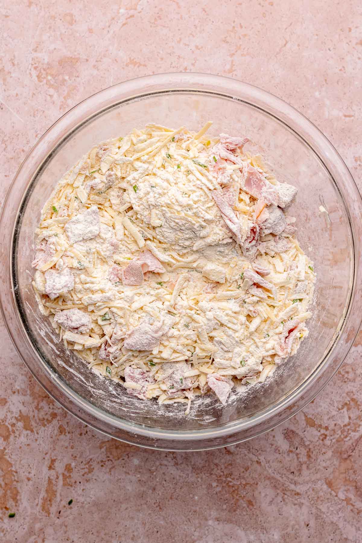 All dry ingredients for ham and cheese scones combined in a bowl.