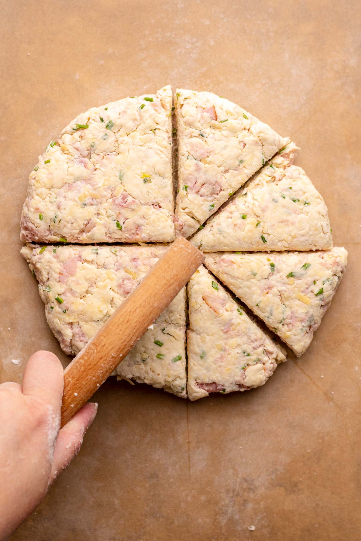 A circle of scone dough gets cut into eight slices.