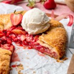 Sliced strawberry rhubarb galette with ice cream on top.