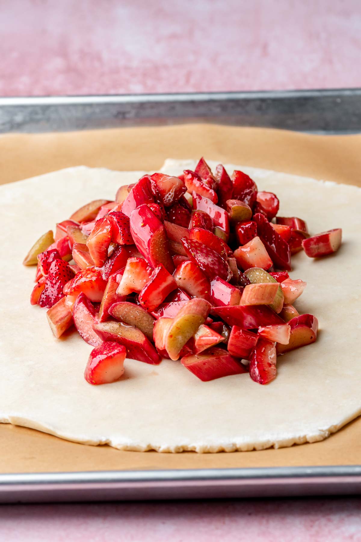 Strawberries and rhubarb mounded in the center of a pie crust.