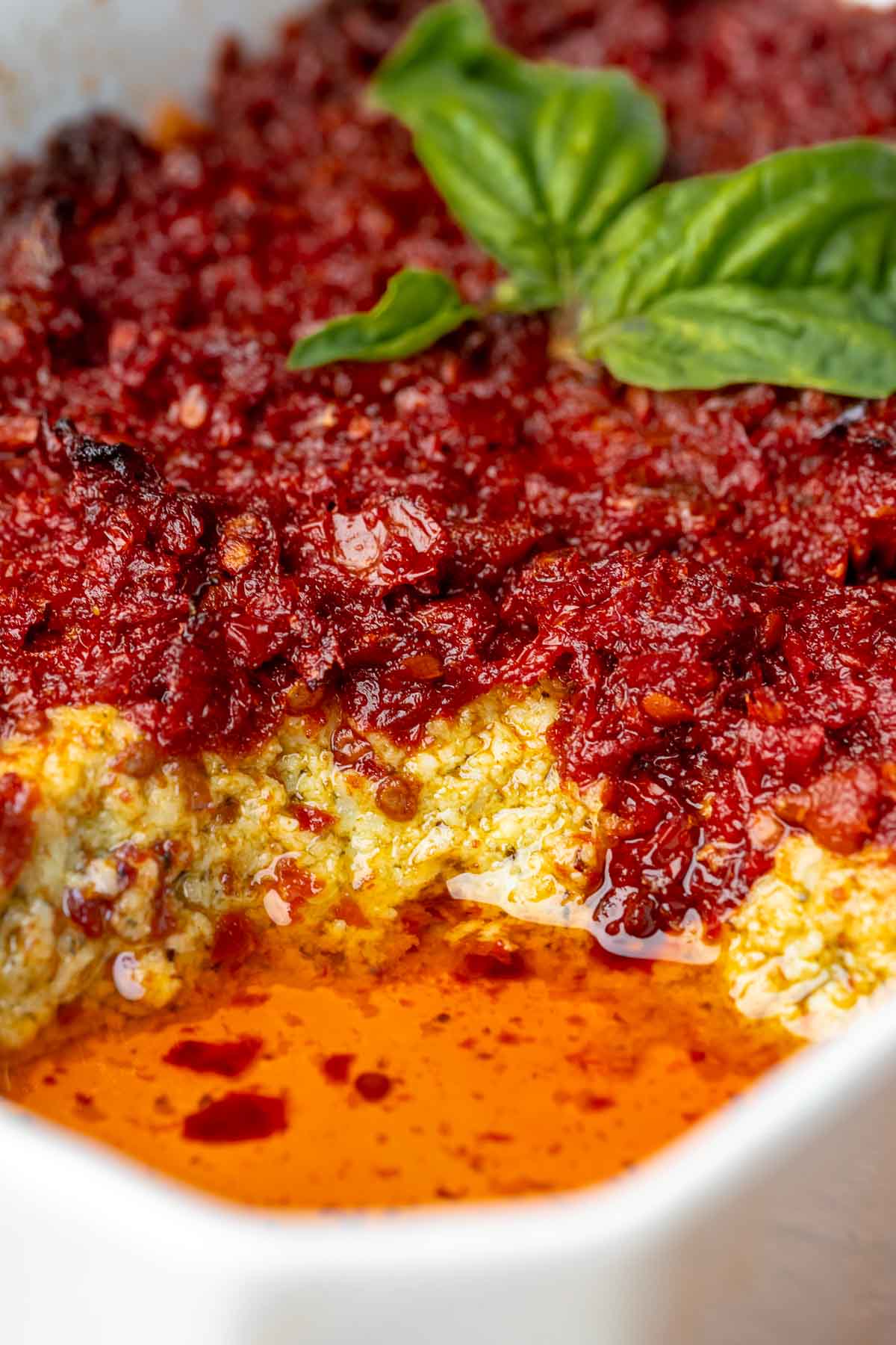 Pesto and sun dried tomato dip in a casserole dish.