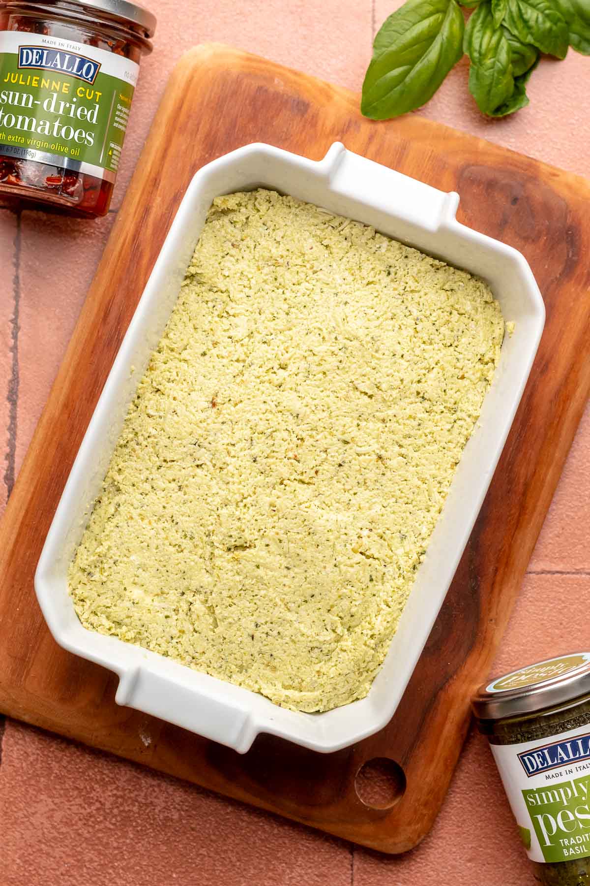 Pesto dip layered in a casserole dish.