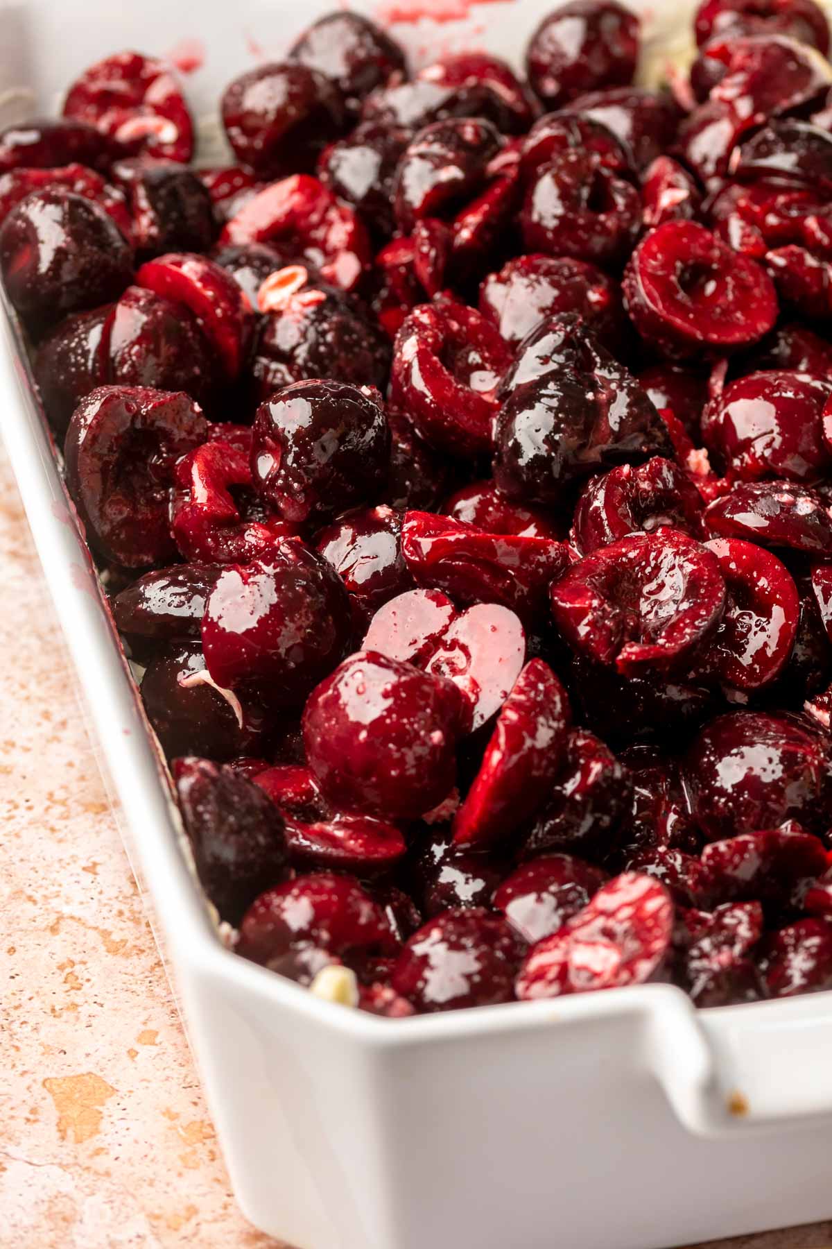 Cherries spread out in a casserole dish.