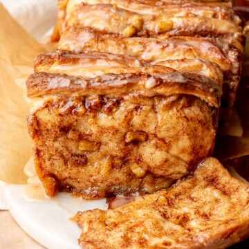 Baked apple fritter pull apart bread with a piece removed.