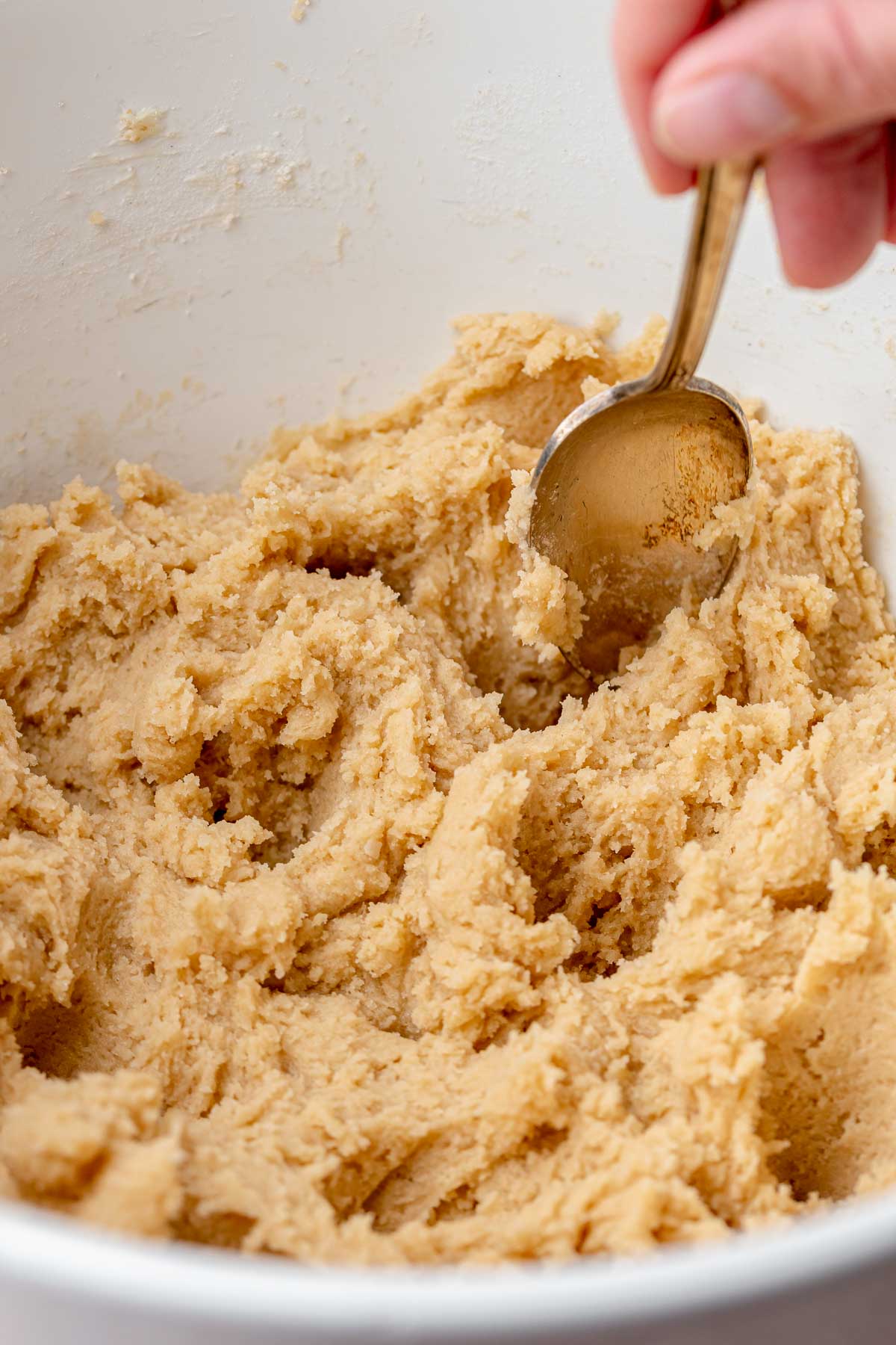 A spoon makes holes in the cookie dough.