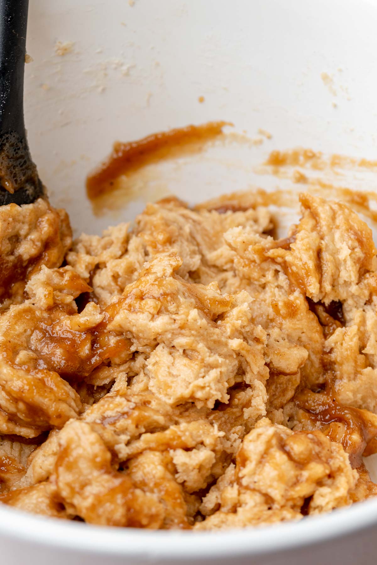 Apple butter cookie dough in a bowl with streaks of apple butter.