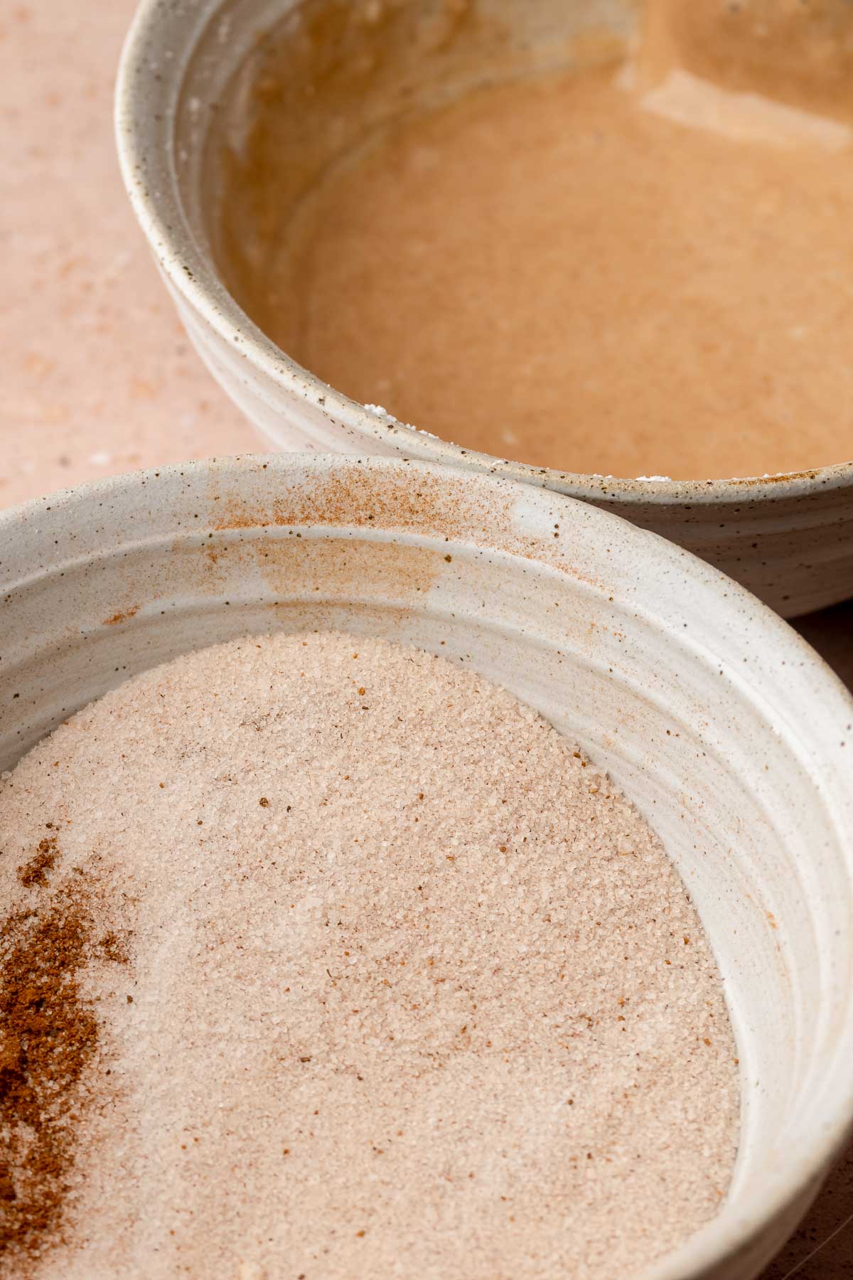 Spiced sugar and apple cider glaze in two separate bowls.