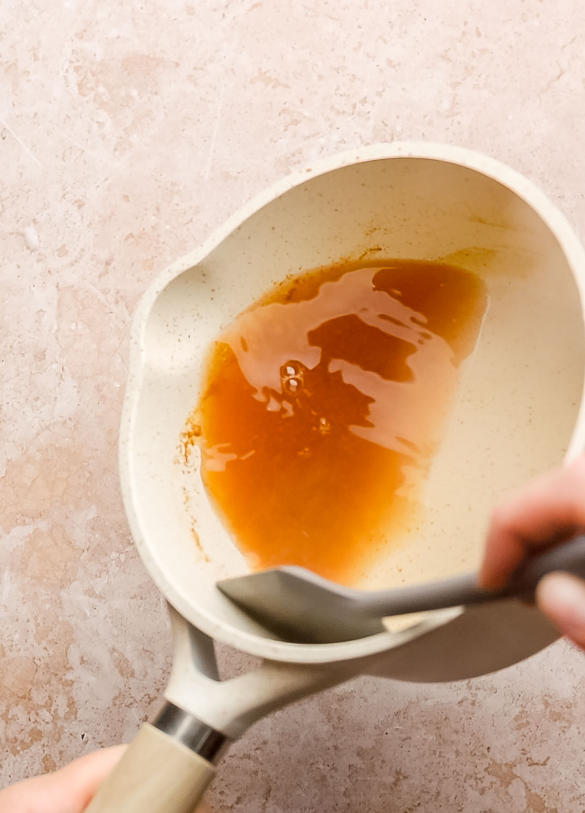 Apple cider reduction in a saucepan.