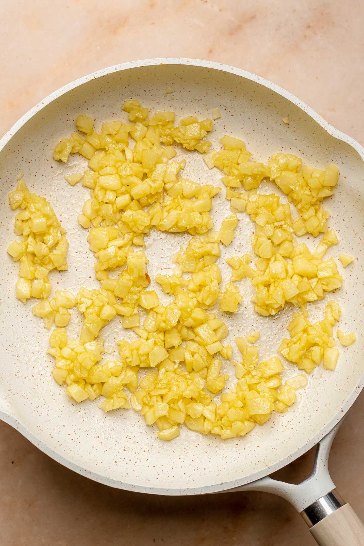 Cooked diced apples in a pan.