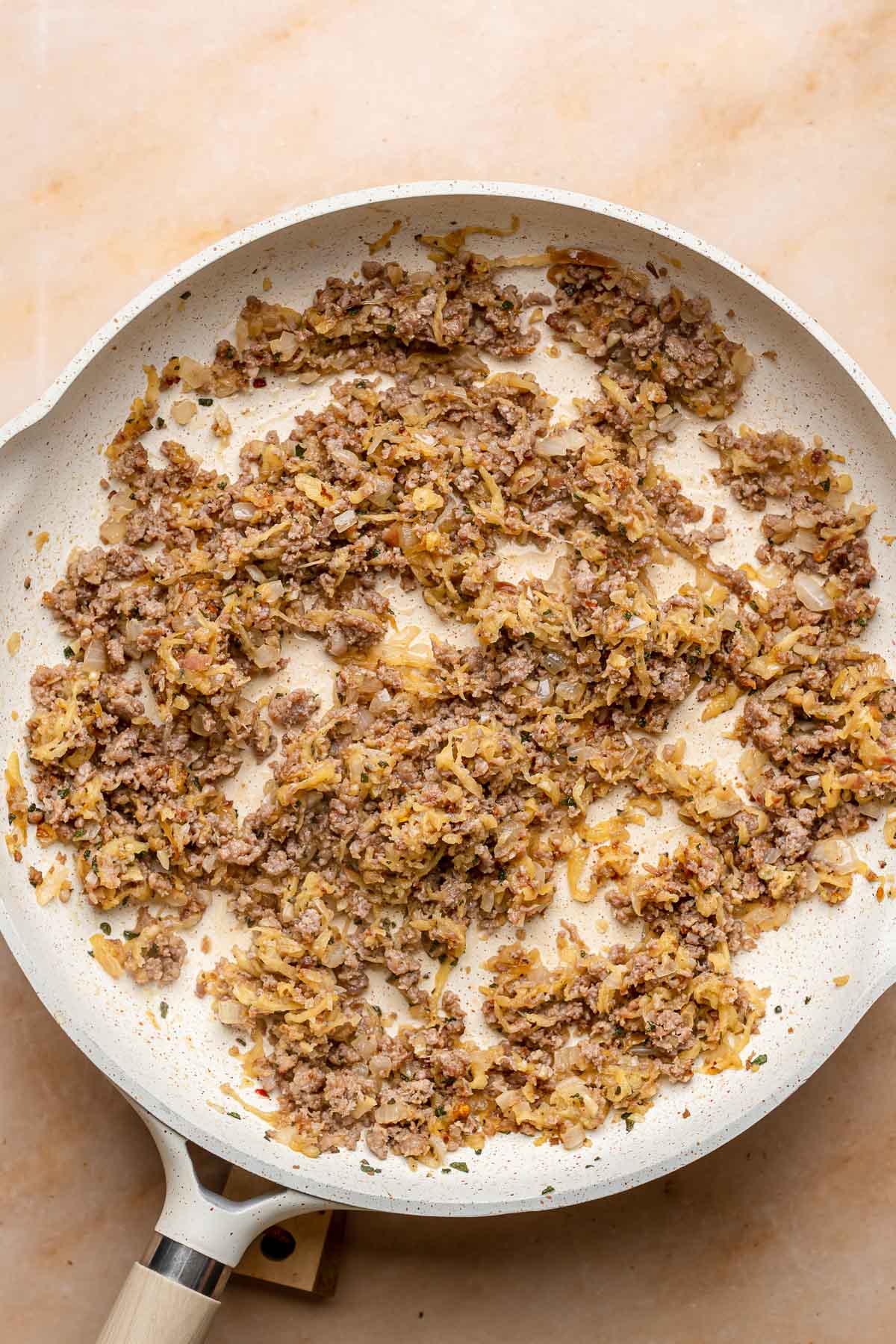 Cooked sausage apple filling in a pan.