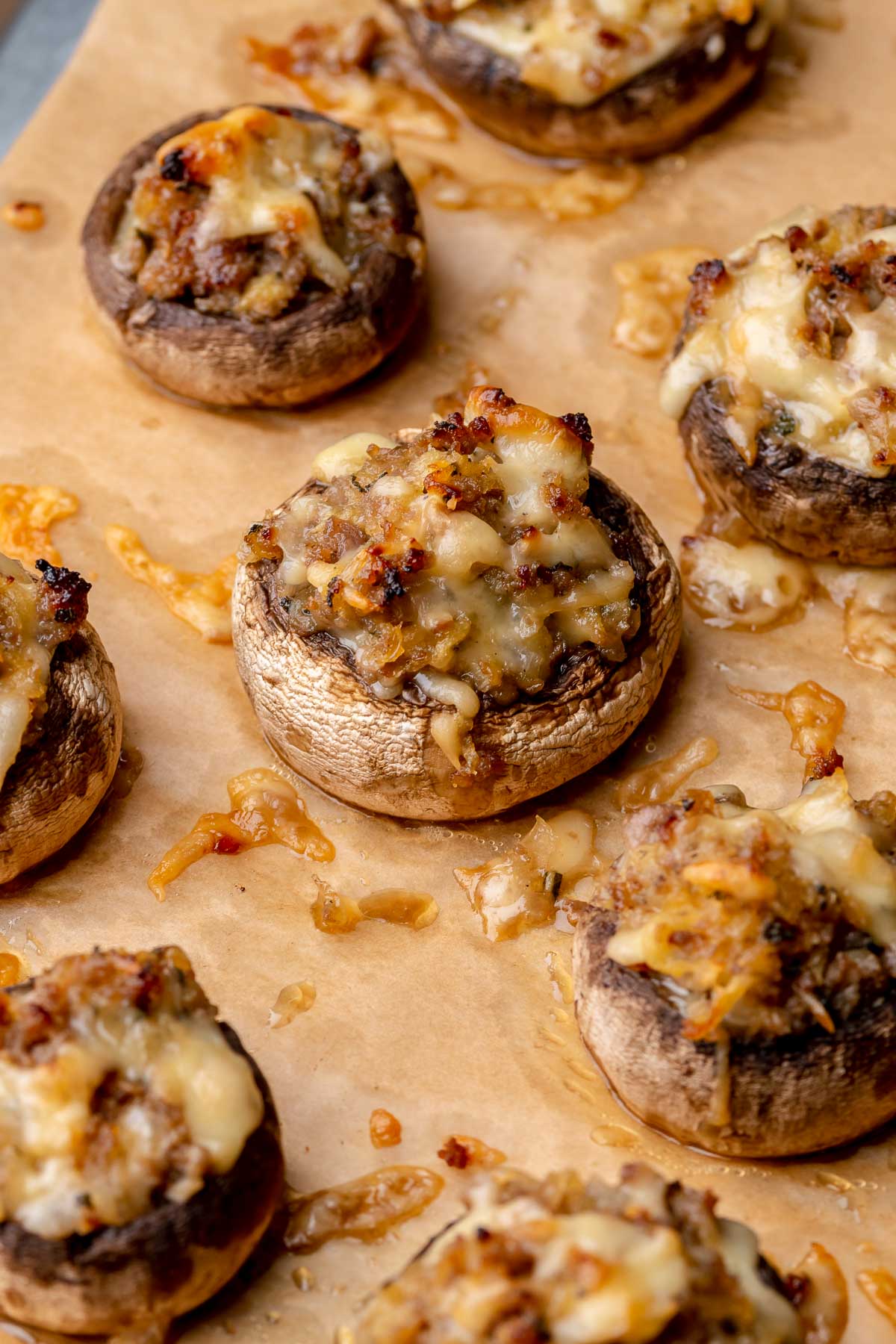 Baked sausage apple stuffed mushrooms on a baking sheet.