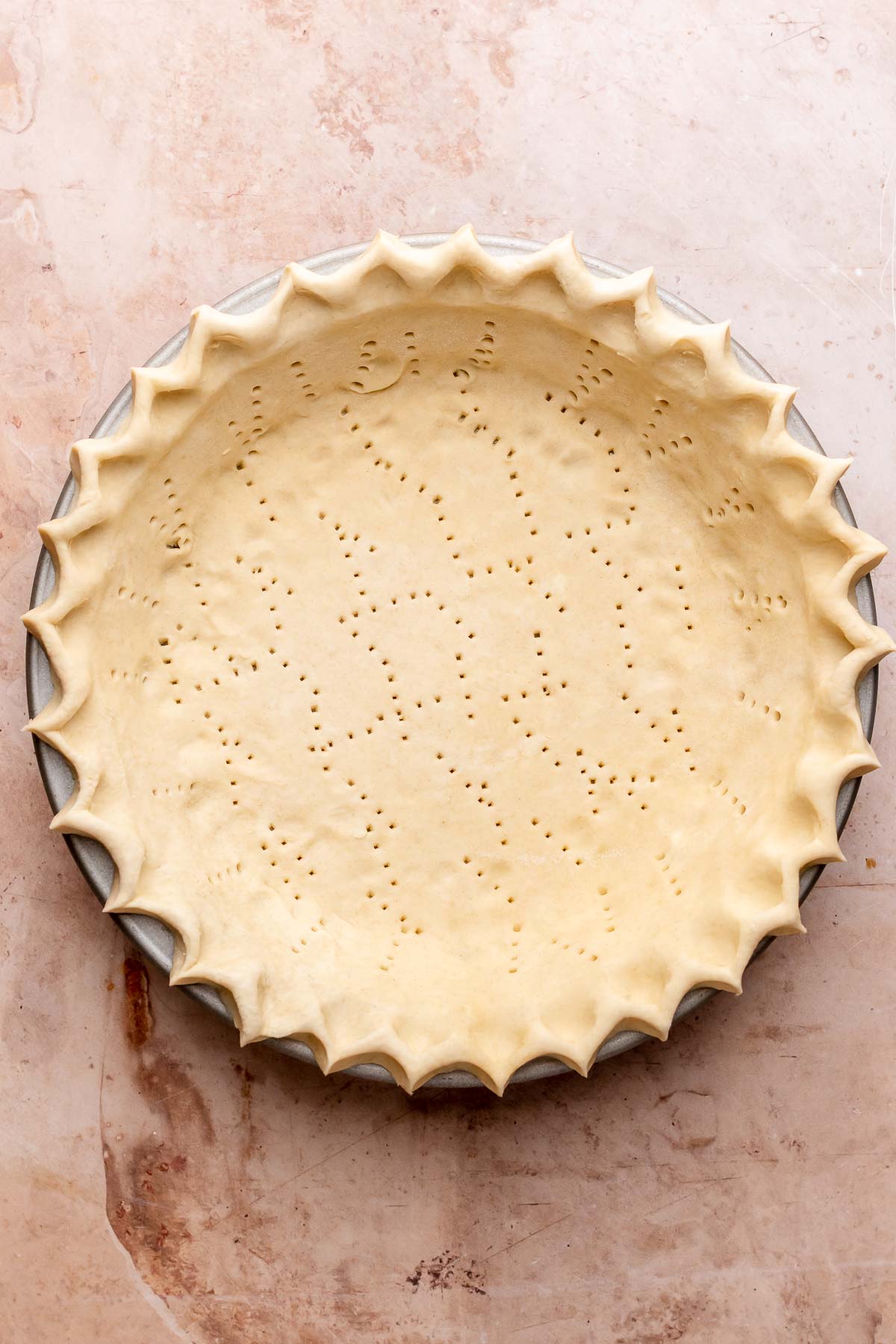 Pre-baked pie crust with fork holes poked into it.