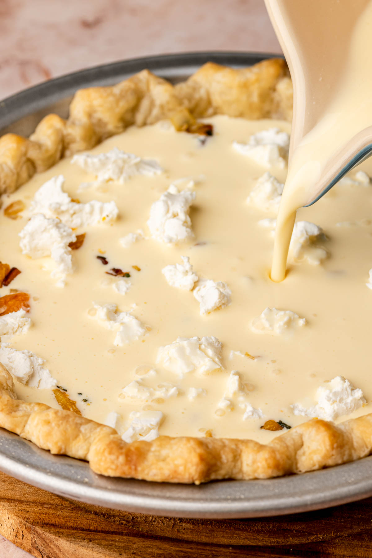 Custard being poured into pie crust.
