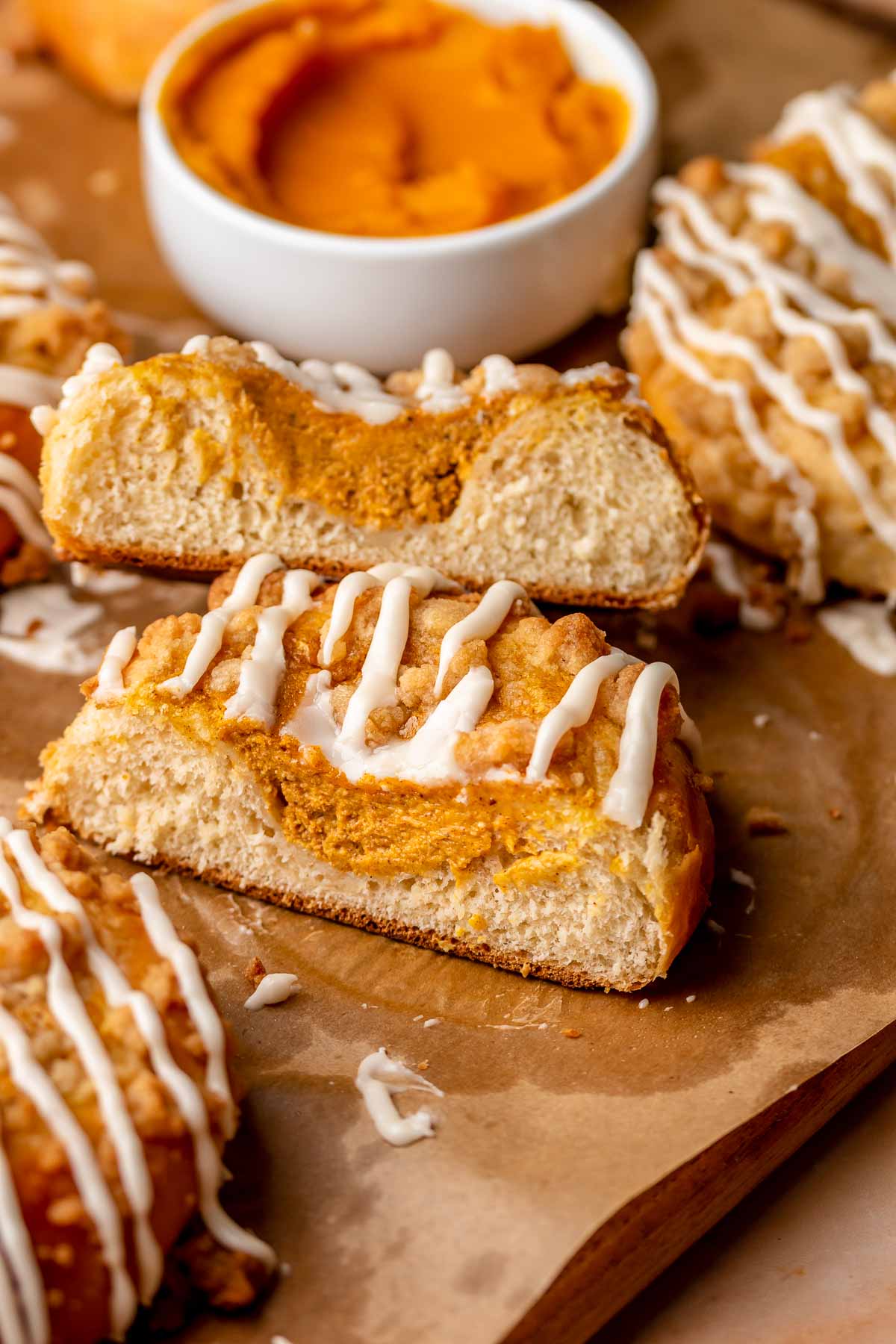 Cut pumpkin brioche buns stacked on top of each other.