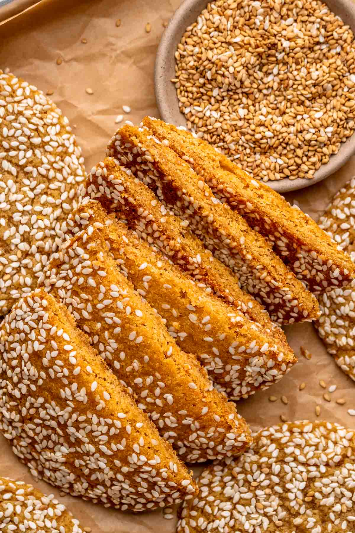 A stack of sesame cookies cut in half laying on their side.