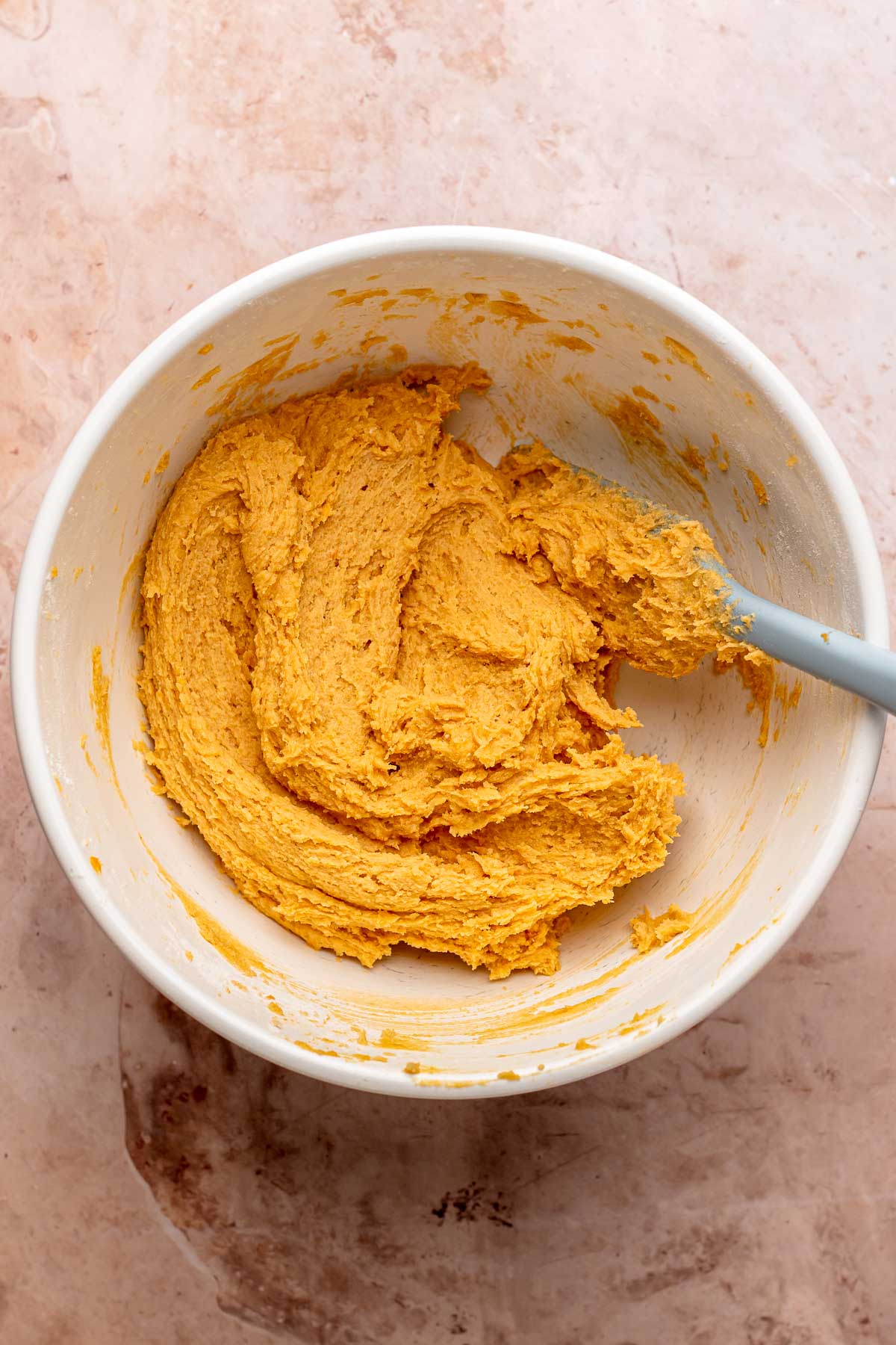 Sweet potato cookie dough in a bowl with a spatula.