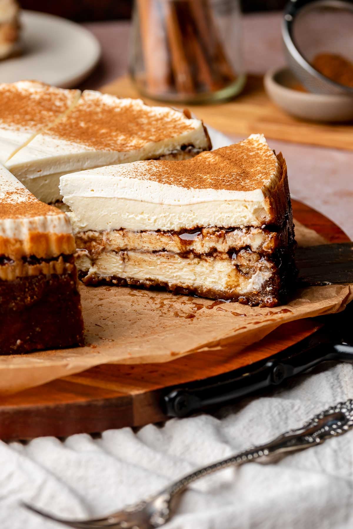 Sliced cinnamon roll cheesecake on a platter.