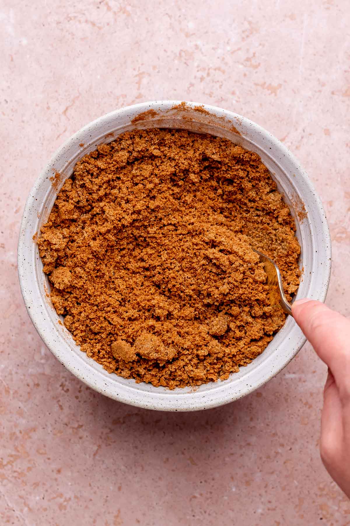 A fork mixes cinnamon sugar in a bowl.