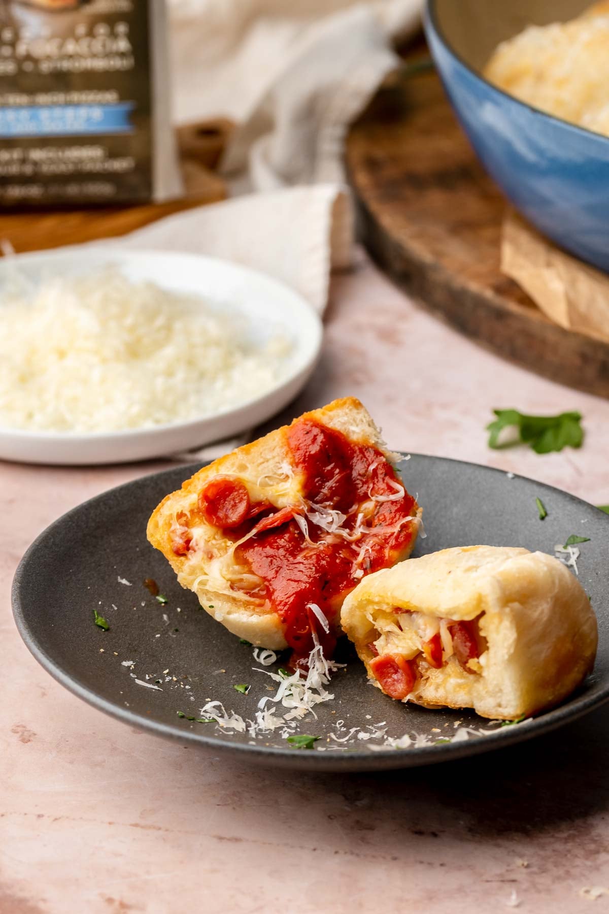 Pizza bite on a plate broken open to show the inside. Marinara is dripping down the side.