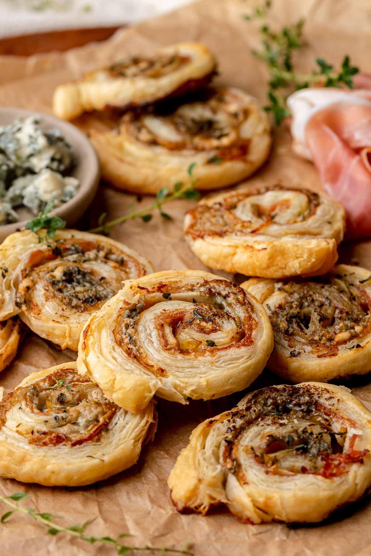 A stack of puff pastry pinwheels on parchment paper.