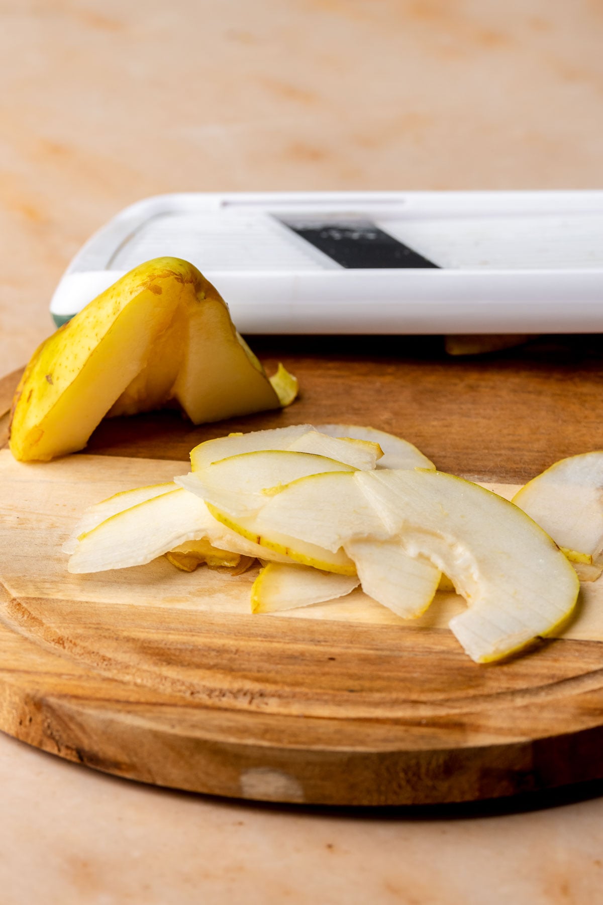 Thinly sliced pears on a cutting board.